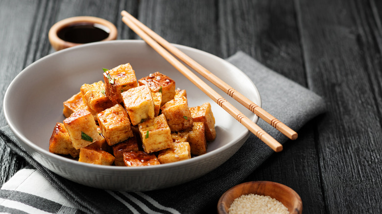 Baked tofu in a round bowl, with chopsticks on top of the bowl