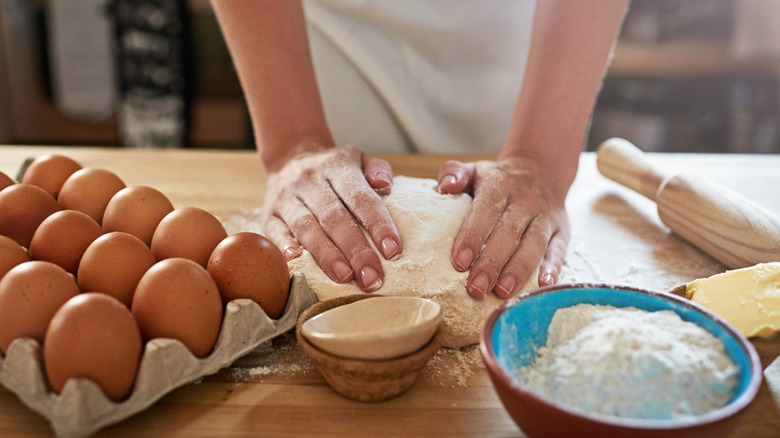 eggs, flour, and, baker hands kneading dough