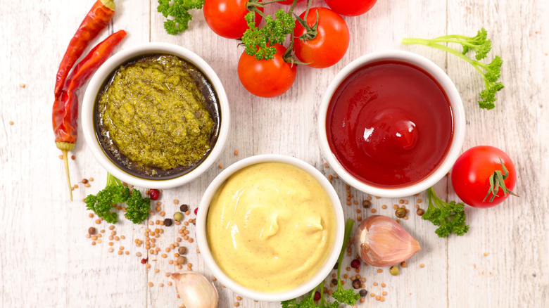 collection of condiments in dishes