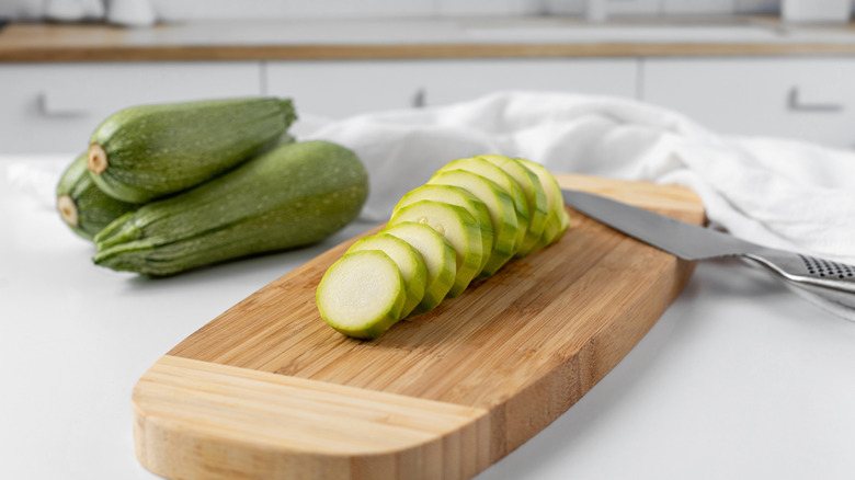sliced zucchini on cutting board with knife