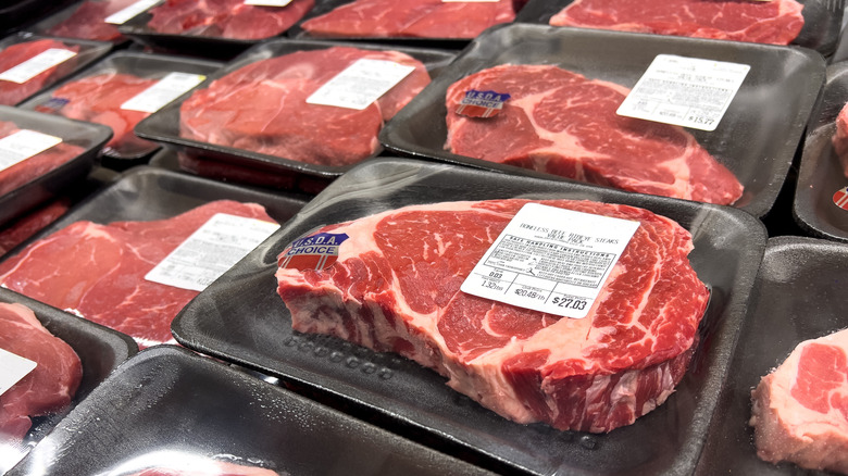 Raw ribeye steaks on display at grocery store