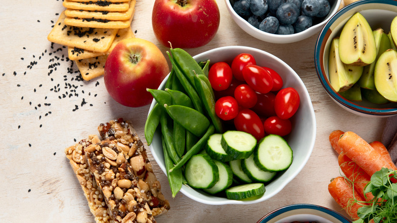small portions of healthy snacks like granola bars, fruit, and vegetables