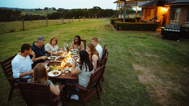 a large group having dinner in a backyard