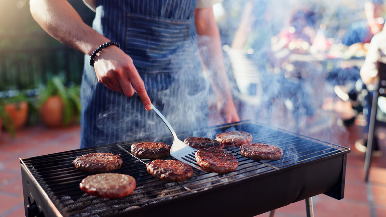 a small outdoor grill with burgers