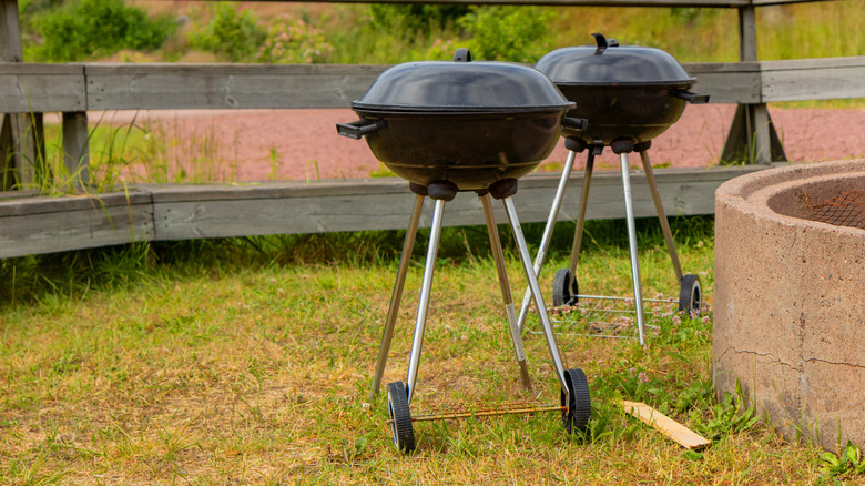 two charcoal kettle grills outside