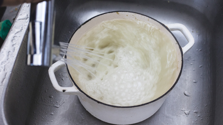 Washing a Dutch oven with water in a sink
