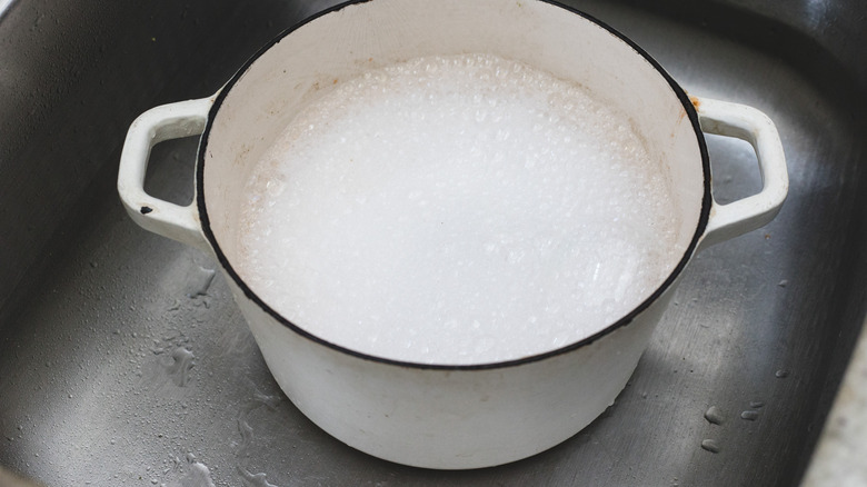 Dutch oven pot filled with warm, soapy water