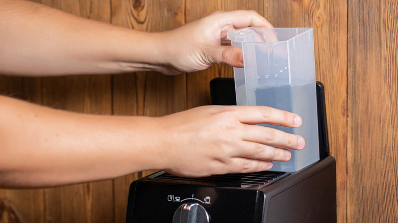 Replacing water container in coffee machine