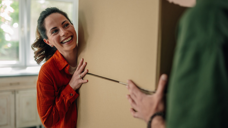 Smiling woman moves refrigerator