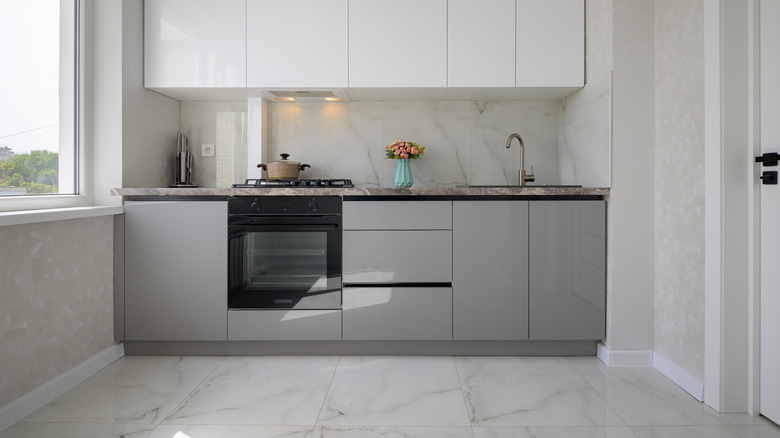 A modern small kitchen design with luxury natural stone flooring tiles