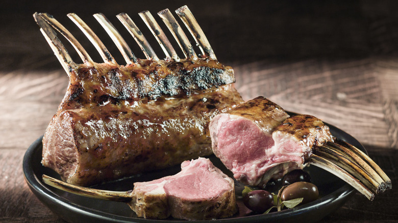 a cooked rack of lamb with one chop in the foreground