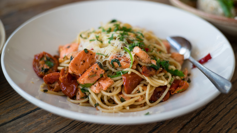 A salmon pasta in a white bowl