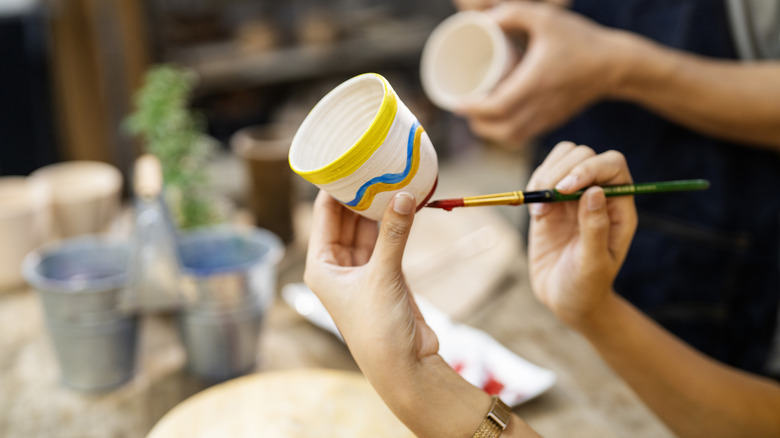 Hand painting a glass at a crafts workshop