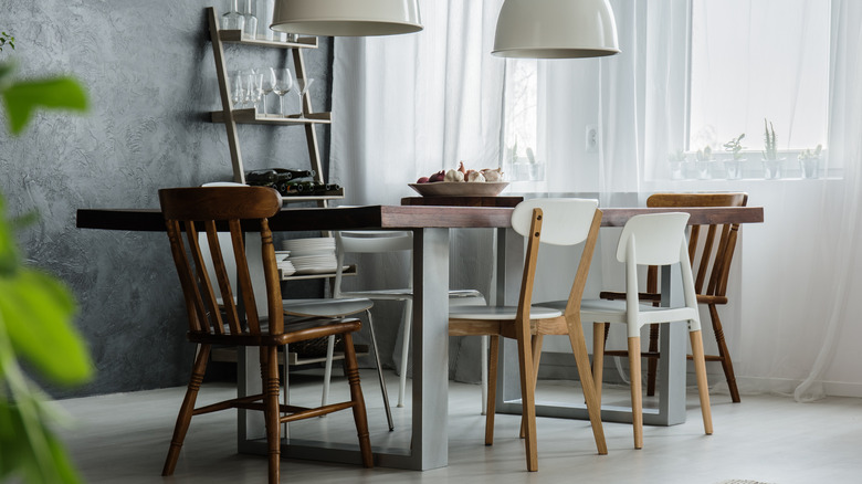 Several mismatched wooden chairs placed around a wooden table