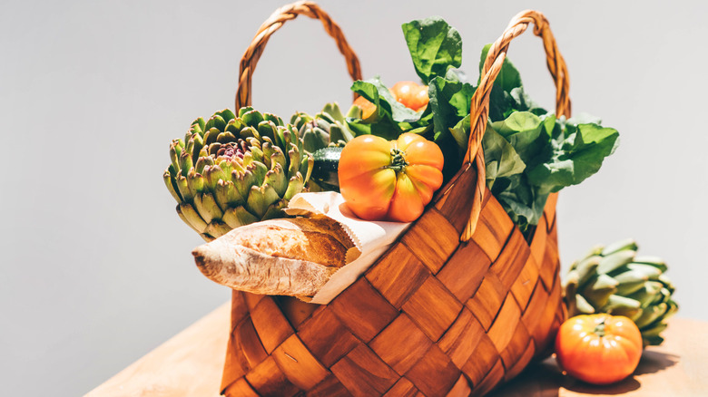 Fresh vegetables and breads loaded in a wicker basket