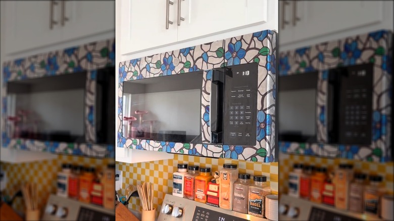 Microwave in kitchen wrapped in floral cling film