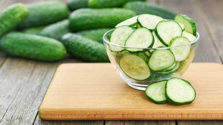 whole cucumbers with cut ones in bowl