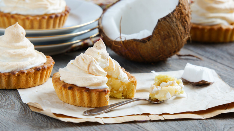 Coconut cream and meringue tarts on table