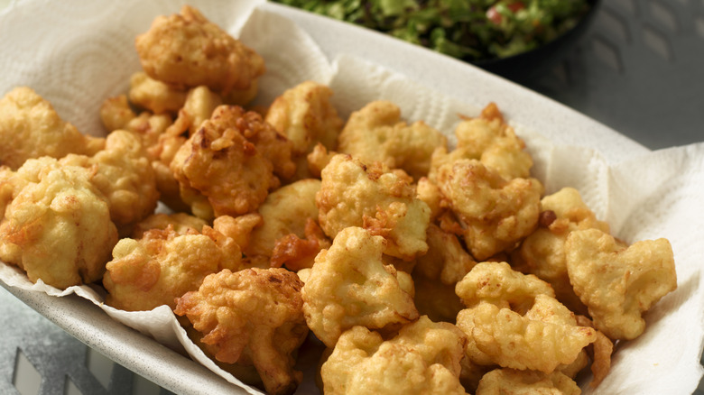 battered and fried cauliflower florets in a basket