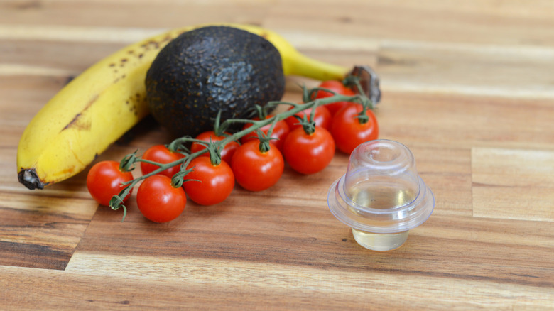 Banana, avocado and tomatoes on a table with a fruitfly trap