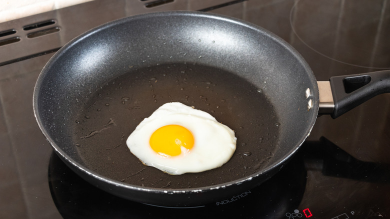 Egg cooking in frying pan on stovetop