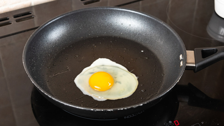 Egg cooking in frying pan on stovetop