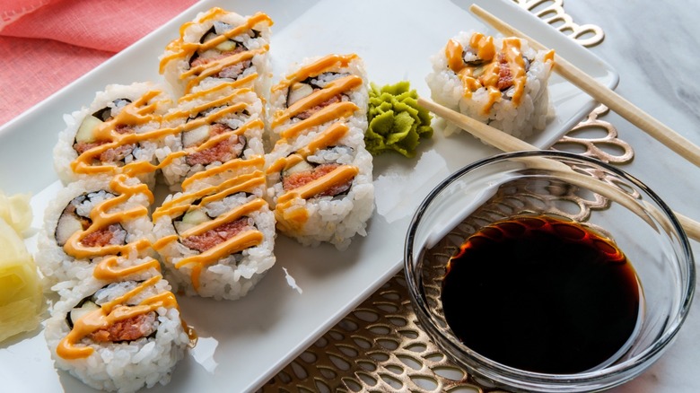 sushi plate with kewpie mayo drizzle and a side of soy sauce