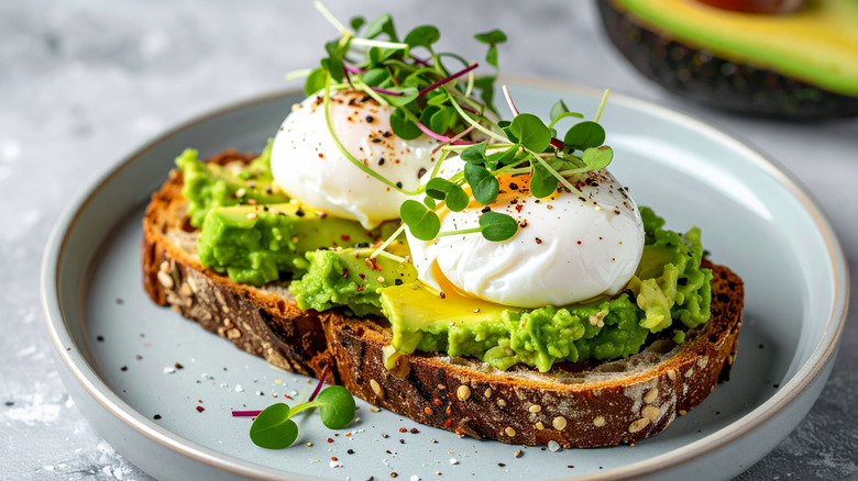 avocado toast with poached eggs and microgreens