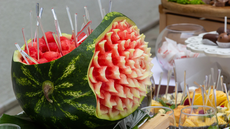 Watermelon with design carved into it, holding fruit