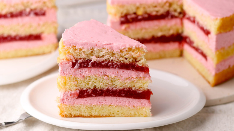 slice of strawberry cake layered with jam and frosting