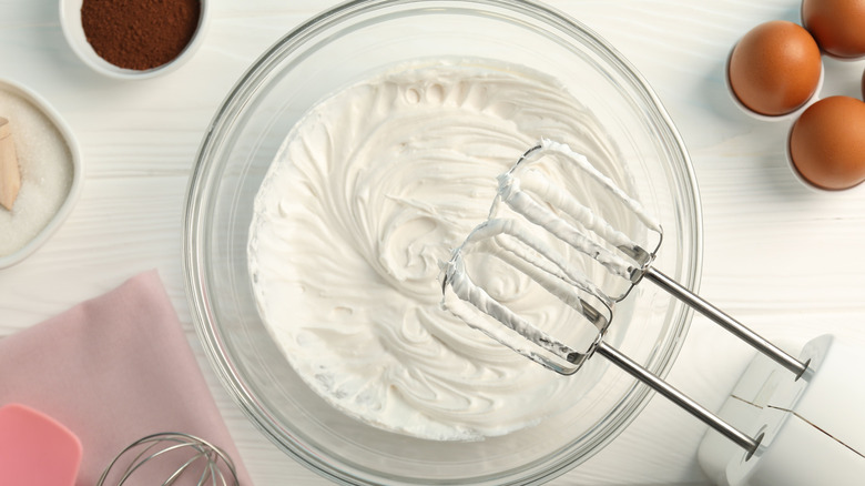 bowl of freshly whipped cream with electric beaters above