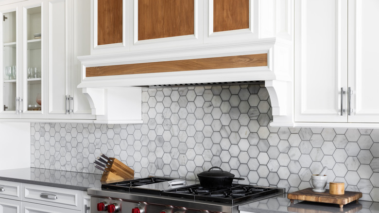 A gray backsplahs behind the stove in a kitchen