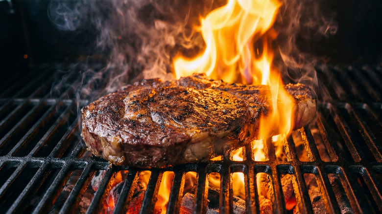 Steak in flames on grill