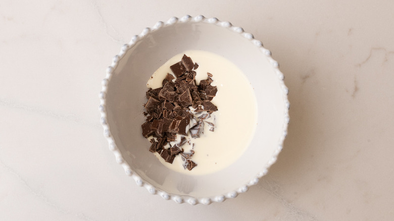 Chopped chocolate and heavy cream in bowl
