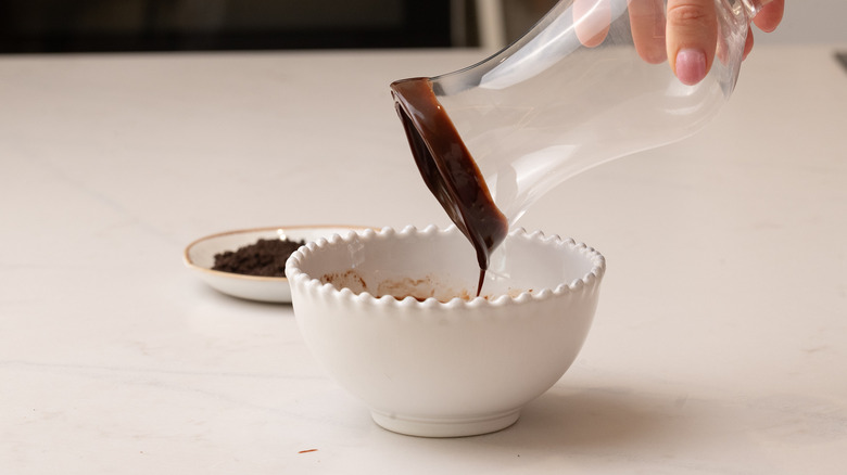 dipping glass into melted chocolate