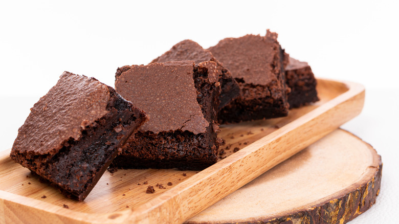 Fudgy brownies on wooden serving tray
