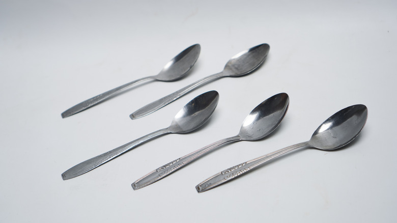 set of silver spoons on gray background