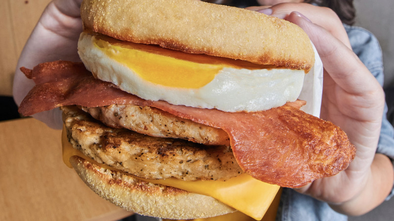 woman holding stacked McMuffin sandwich