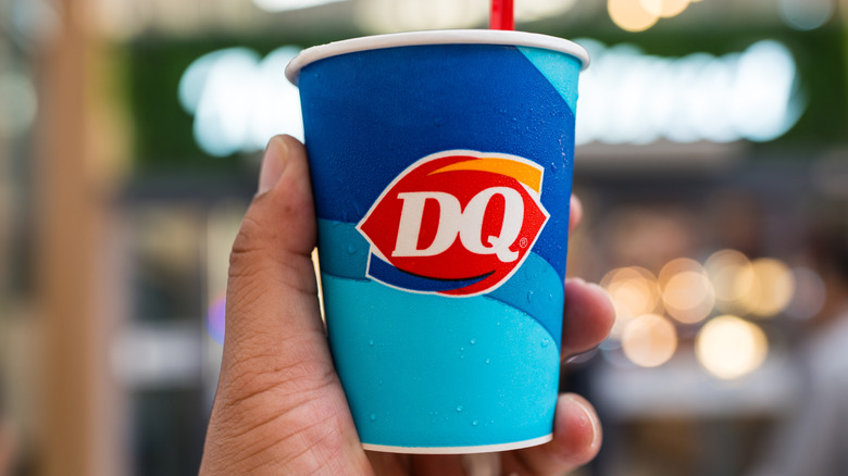 A person is holding a Dairy Queen ice cream cup.