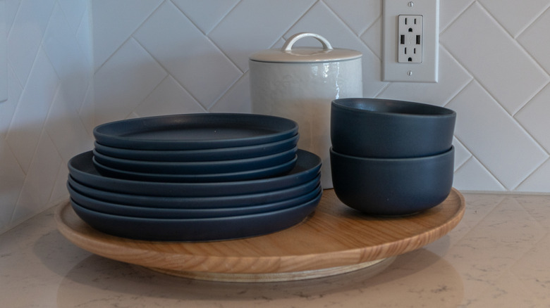Wooden lazy Susan with dishes stacked on top of it