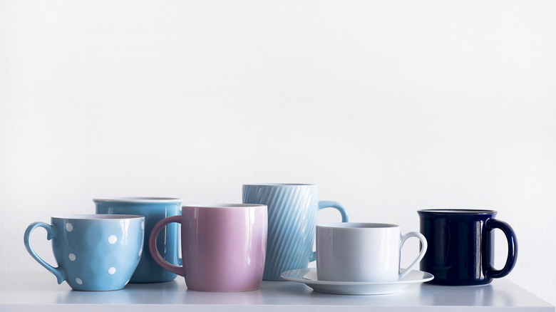 Variety of mugs on white table