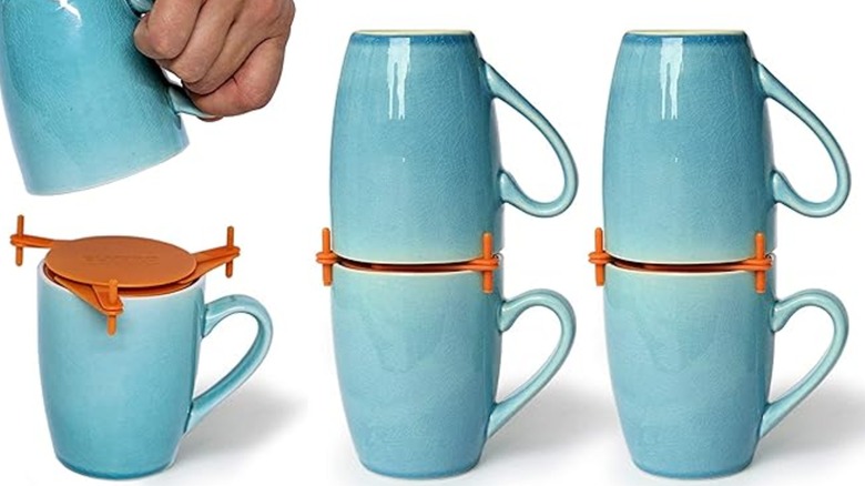Stack of colorful mugs against pick background