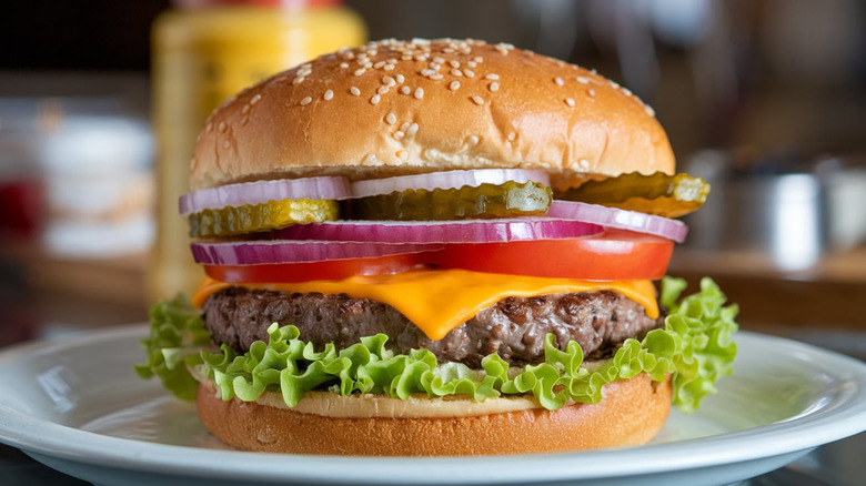 Hamburger with pickles, onions, tomatoes, cheese, and lettuce