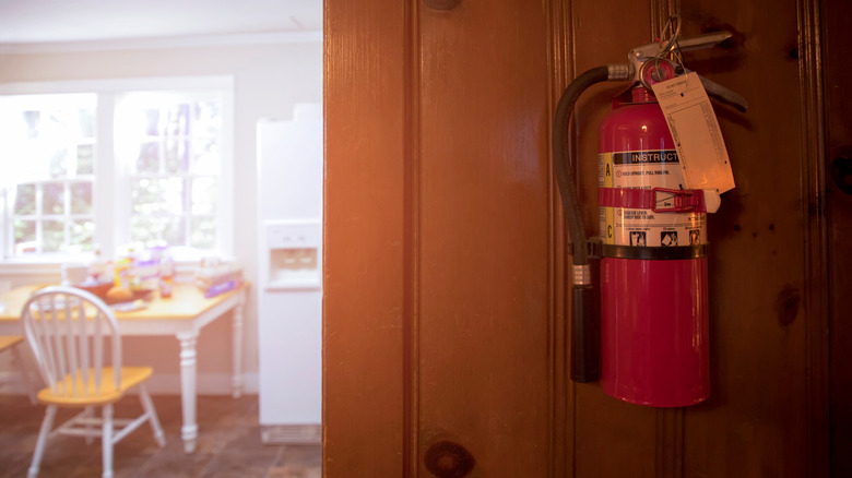 A fire extinguisher mounted on the wall of a kitchen