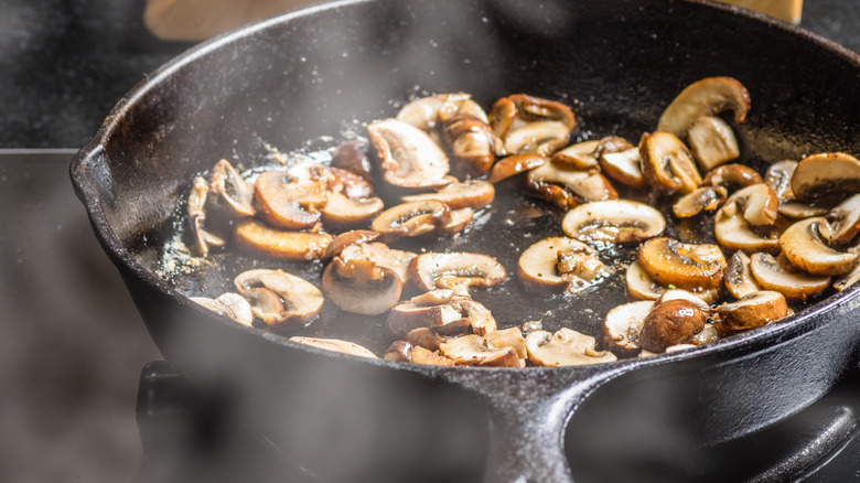 Sauteing sliced mushrooms in a cast iron skillet