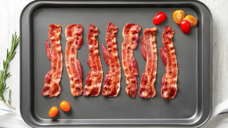 bacon on baking sheet with tomatoes