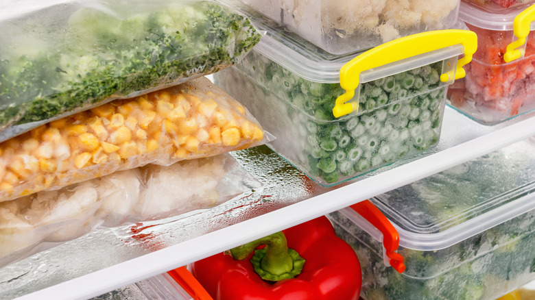 Various vegetables in a freezer, some with ice crystal formation