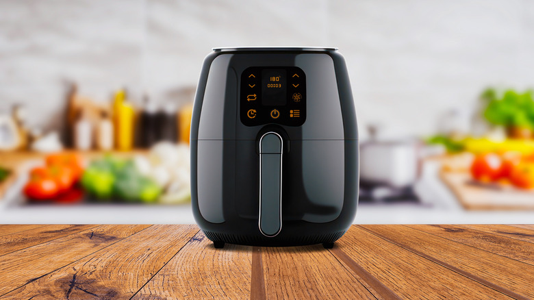Black air fryer on wooden counter