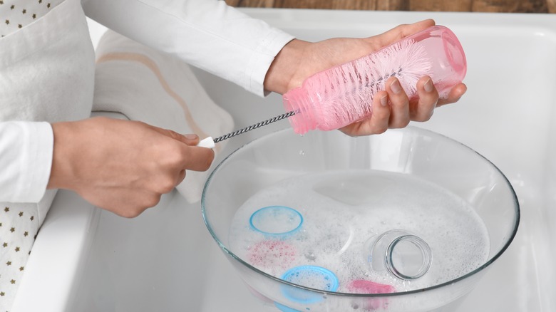 Woman using a bottle brush to clean a water bottle