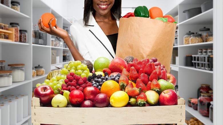 Woman holding an abundance of fruit